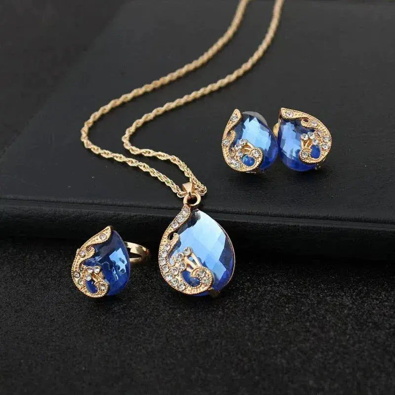 Goldenes Halsketten- und Ohrring-Set mit blauen Kristallen
